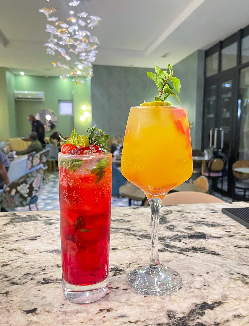 Strawberry mojito and an orange cocktail on the bar