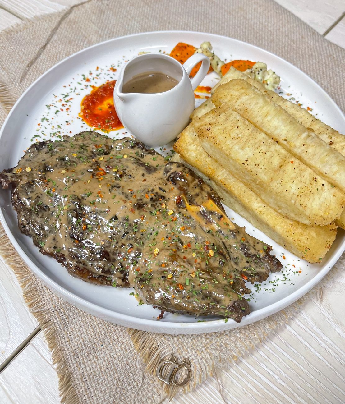 Grilled rib eye steak in peppercorn sauce with yam fries
