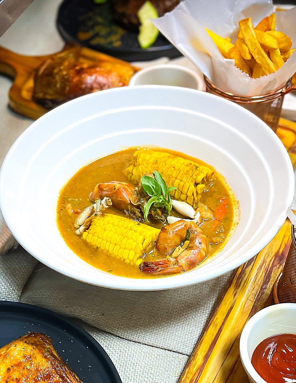 Seafood boil with prawns, crab and sweet corn in tomato broth